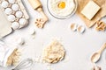 Raw dough ready for kneading on white table. Bakery ingredients, eggs, flour, butter. Shapes for making cookies. Royalty Free Stock Photo