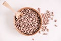 Raw dry beans in a wooden bowl with a spoon on a white background. Top view. Copy, empty space for text Royalty Free Stock Photo