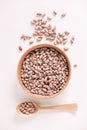 Raw dry beans in a wooden bowl with a spoon on a white background. Top view. Copy, empty space for text Royalty Free Stock Photo