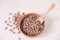 Raw dry beans in a wooden bowl with a spoon on a white background. Top view. Copy, empty space for text Royalty Free Stock Photo