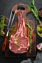 Raw dry steak tomahawk on a black background. Steak Cowboy. Barbecue. Top view. Royalty Free Stock Photo