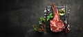 Raw dry steak tomahawk on a black background. Steak Cowboy. Barbecue. Top view.