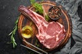 Raw dry steak tomahawk on a black background. Steak Cowboy. Barbecue. Top view. Royalty Free Stock Photo