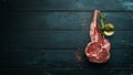 Raw dry steak tomahawk on a black background. Steak Cowboy. Barbecue. Top view. Royalty Free Stock Photo