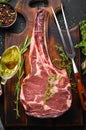 Raw dry steak tomahawk on a black background. Steak Cowboy. Barbecue. Top view. Royalty Free Stock Photo