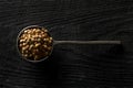 Raw, dry, uncooked brown lentil legumes in metal scoop on wood table background top view flat lay from above