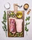 Raw duck breast with rosemary, parsley, pepper, salt and oil, on a cutting board wooden rustic background top view close up