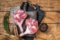 Raw duck legs with spices and chef cleaver on a wooden board. Wooden background. Top view