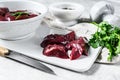 Raw duck liver in a bowl. Gray background. Top view