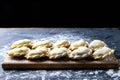 Raw dumpling with potatoes. Preparation dumplings on a wooden board on dark background. Top views, close-up