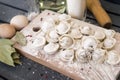 Raw dumplings in flour on a cutting Board, semi-finished products, eggs ,whisk, rolling pin, Bay leaf