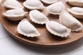 Raw dumplings (varenyky) on wooden plate, closeup Royalty Free Stock Photo