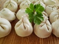 Raw dumplings on a wooden board, parsley preparation