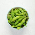 Raw edamame soya beans with salt and sauce on light gray background