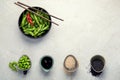 Raw edamame soya beans with salt and sauce on light gray background