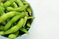 Raw edamame soya beans with salt and sauce on light gray background