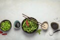 Raw edamame soya beans with salt and sauce on light gray background