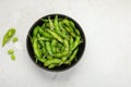 Raw edamame soya beans with salt and sauce on light gray background