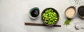 Raw edamame soya beans with salt and sauce on light gray background