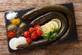 Raw eel with spices, vegetables and lemon close-up on a slate board. horizontal top view Royalty Free Stock Photo