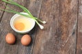 Raw egg in a bowl selective focus and onion on wooden table Royalty Free Stock Photo