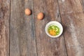 Raw egg in a bowl selective focus and onion on wooden table Royalty Free Stock Photo