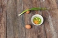 Raw egg in a bowl selective focus and onion on wooden table Royalty Free Stock Photo