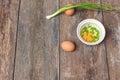 Raw egg in a bowl selective focus and onion on wooden table Royalty Free Stock Photo