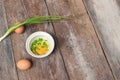 Raw egg in a bowl selective focus and onion on wooden table Royalty Free Stock Photo