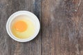 Raw egg in a bowl selective focus on wooden table Royalty Free Stock Photo