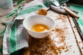 Raw egg broken into a white bowl with yolk and protein, next to the shell, fork and towel on a rusty metal background as at home i Royalty Free Stock Photo