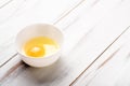 Raw egg in a plate on a white wooden background Royalty Free Stock Photo