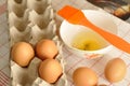 Raw eggs in box and egg yolk on plate with spices and orange brush Royalty Free Stock Photo