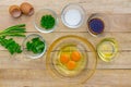 Raw eggs and ingredients on wooden background.