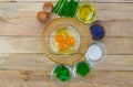 Raw eggs and ingredients on wooden background.