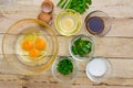 Raw eggs and ingredients on wooden background.