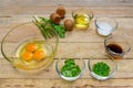 Raw eggs and ingredients on wooden background.