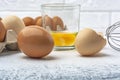 Raw eggs in package and whisk on kitchen table Royalty Free Stock Photo