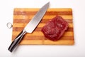 Raw Entrecote steak meat With Pepper and Salt On Wooden Board in a kitchen with a knife isolated on white