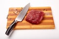 Raw Entrecote steak meat With Pepper and Salt On Wooden Board in a kitchen with a knife isolated on white