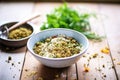 raw falafel mix in a bowl with spoon, chickpeas visible