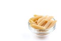 Raw feathers macaroni in bowl. Italian pasta close up, isolated on the white background Royalty Free Stock Photo