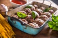 Raw feef meat balls basil tomato sauce garlic and spaghetti on butcher board Royalty Free Stock Photo