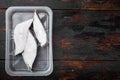 Raw fillets frozen halibut airtight vacuum pack, on old dark wooden table background, top view flat lay, with copy space for text