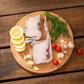 Raw fish cod on a tray, lemon tomato and pepper, wooden table in rustic style. Copy space Royalty Free Stock Photo