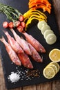 Raw fish red mullet with vegetables and lemon close-up on the kitchen board. Vertical top view Royalty Free Stock Photo