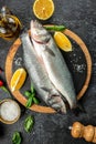 raw fish sea bass with ingredients on a dark background. vertical image. top view. place for text Royalty Free Stock Photo