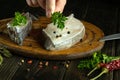 Raw fish steaks on a kitchen board before cooking. The chef hand adds fragrant parsley to the fish Royalty Free Stock Photo