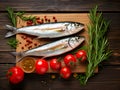 Raw fish, tomatoes and rosemary on wooden table, flat lay