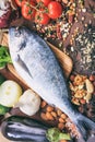 Raw fish on wooden background. Fresh, healthy uncooked whole silver color fish on wood cutting board Royalty Free Stock Photo